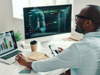 Young African man using computer and smiling while working in the office